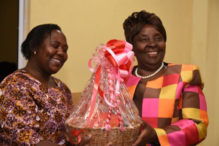 Dr Adelaide Mbithi receives gifts from Ms Dianrose Ivati during end-of-year 2019 staff party for the Examinations