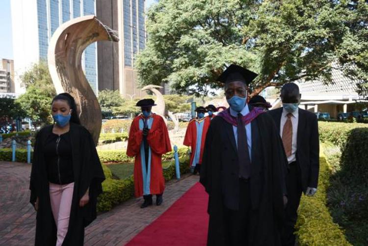 The academic procession at the Fountain of Knowledge towards Taifa Hall.
