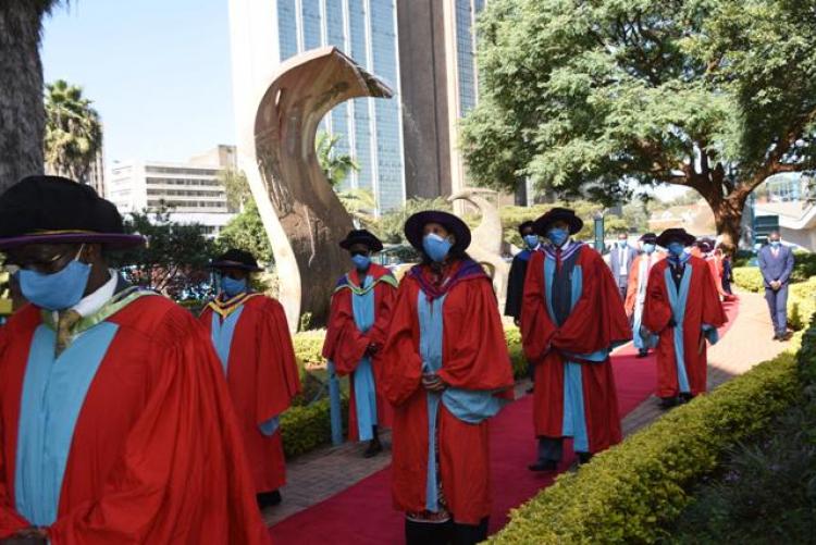 The academic procession at the Fountain of Knowledge towards Taifa Hall.