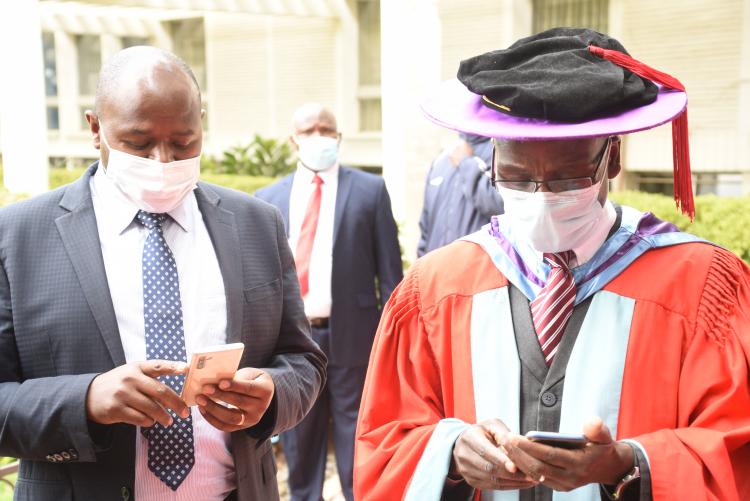The Director of ICT Mr. Paul Kariuki consults with Prof. Ogeng'o during the VC's Address to Freshers on 3rd September 2020