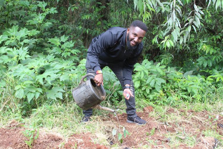 A Staff member from Academic ICT Section takes part in Tree planting exercise